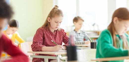 School children filling test blank at exam